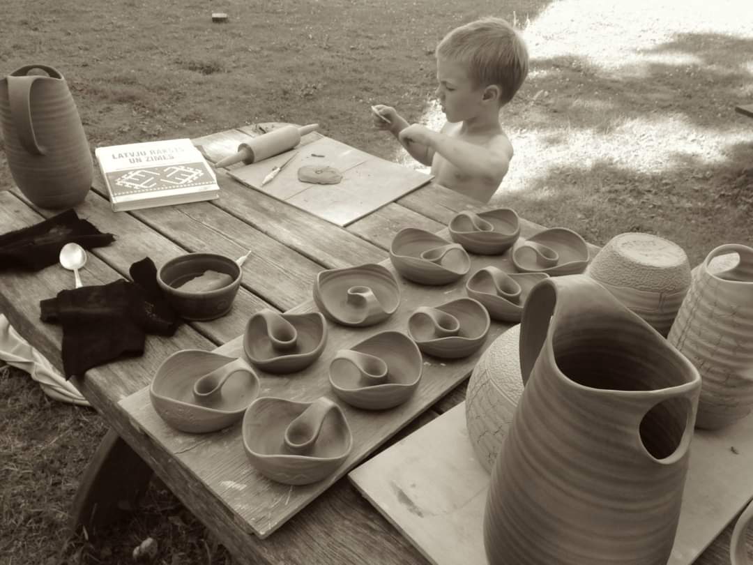 Matiass Preiss as a child working clay at an outdoor table among his family's pots